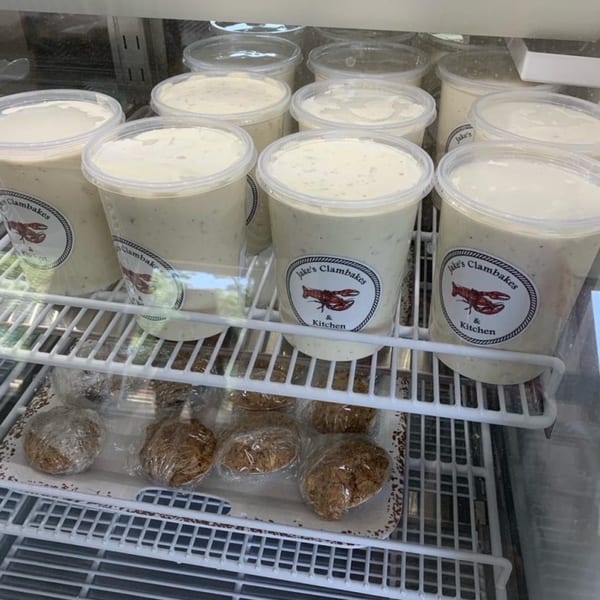 A refrigerated display case filled with Jake's Clambakes & Kitchen clam chowder and wrapped cookies.